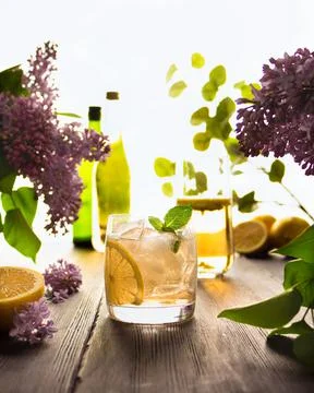 Cold drink lemonade with ice, mint and lemon in a glass glass on a wooden tab Stock Photos