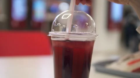 A cold drink or non-alcoholic cocktail of red color with ice, which is stirred Stock Footage 312603773