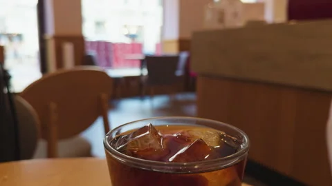 Cold drink scene. Chilled beverage beside shopping area. Icy drink located near Stock Footage 332874558