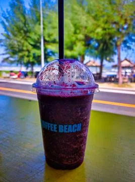 Cold drink served at Coffee Beach during a sunny day by the water with tree.. Stock Photos