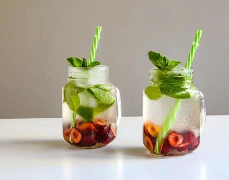 Cold drinks in small bottles. Cherries mint lemonade. Mojito coctail. Stock Photos
