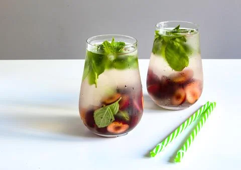 Cold drinks in small bottles. Cherries mint lemonade. Mojito coctail. Stock Photos