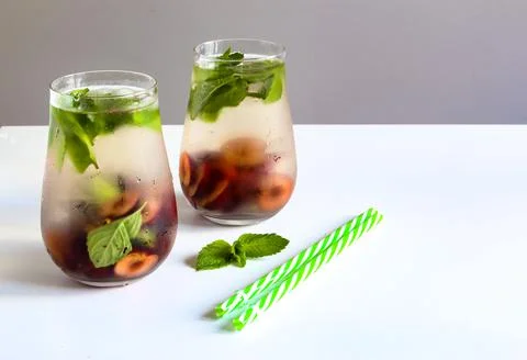 Cold drinks in small bottles. Cherries mint lemonade. Mojito coctail. Stock Photos