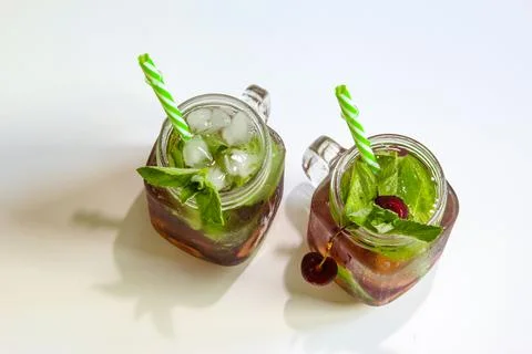 Cold drinks in small bottles. Cherries mint lemonade. Mojito coctail. Stock Photos