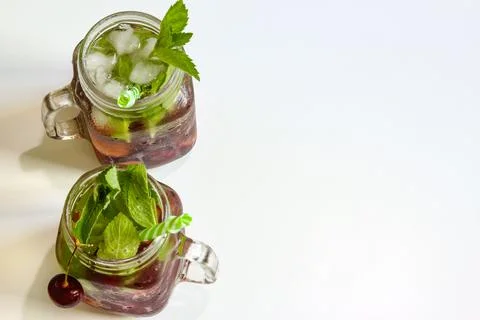 Cold drinks in small bottles. Cherries mint lemonade. Mojito coctail. Stock Photos