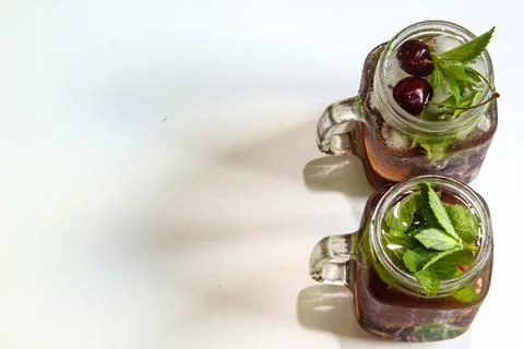 Cold drinks in small bottles. Cherries mint lemonade. Mojito coctail. Stock Photos