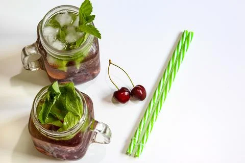 Cold drinks in small bottles. Cherries mint lemonade. Mojito coctail. Stock Photos