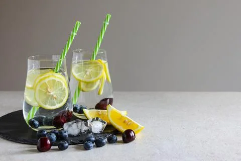 Cold drinks in small bottles. Cherries and lemon lemonade. Mojito coctail. Stock Photos