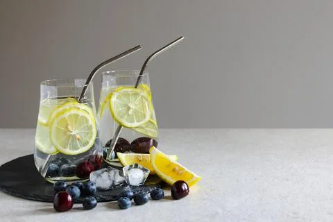 Cold drinks in small bottles. Cherries and lemon lemonade. Mojito coctail. Stock Photos