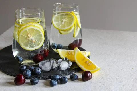 Cold drinks in small bottles. Cherries and lemon lemonade. Mojito coctail. Stock Photos