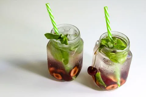 Cold drinks in small bottles. Cherries mint lemonade. Mojito coctail. Stock Photos