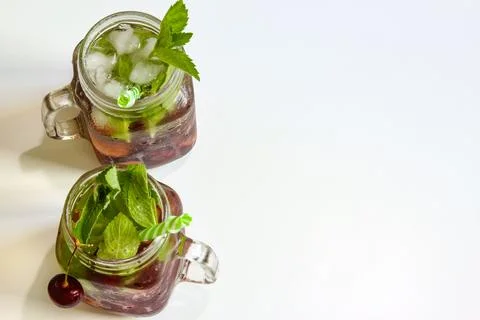 Cold drinks in small bottles. Cherries mint lemonade. Mojito coctail. Stock Photos