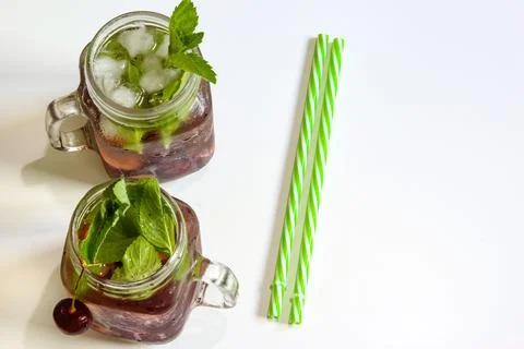 Cold drinks in small bottles. Cherries mint lemonade. Mojito coctail. Stock Photos