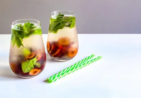 Cold drinks in small bottles. Cherries mint lemonade. Mojito coctail. Stock Photos