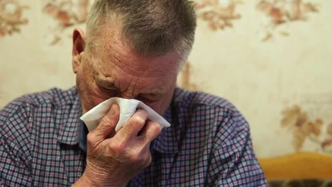 A cold elderly man scribbles snot into a handkerchief and wipes his nose Stock Footage 94992952