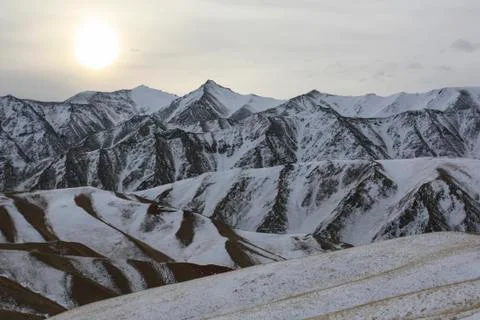 Cold evening sun over a mountain pass in winter. Stock Photos