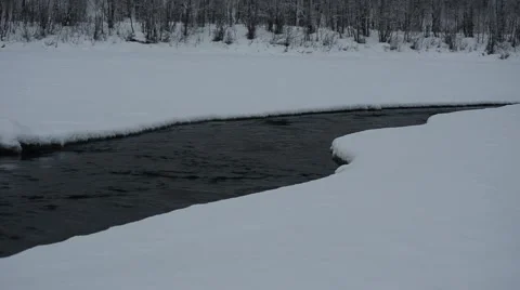 Cold flowing river water in winter through a hole in the river ice in norway Stock Footage 47262129