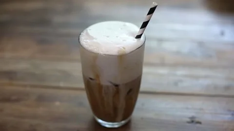 Cold foam iced coffee latte cappuccino cocktail drink overflowing Stock Footage 137873254