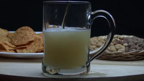 Cold fresh beer is pouring from the top into the glass forming foam Video stock 78417853