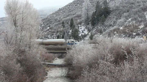 Cold Frosted stream facing highway semi-truck passes. Video stock 33045985