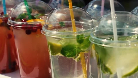 Cold fruit lemonade in transparent plastic glasses is on the bar counter outside Stock Footage 108777313