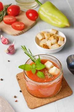 Cold gazpacho soup in a small serving jar with basil and croutons. Close-up on a Stock Photos