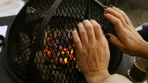 Cold hands. Woman's hands close-up, woman warms her hands by the fire Stockbeeldmateriaal 89901683