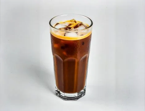 Cold Iced Coffee with Ice Cubes in Tall Glass Isolated on Light Background .. Stock Photos