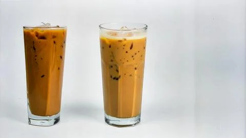 Cold Iced Coffee with Ice Cubes in Tall Glass Isolated on Light Background .. Stock Photos