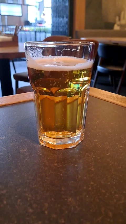 Cold Lager Beer with Bubbles and Foam in Glass on Dark Table Stock Footage 327651044