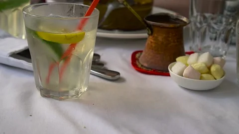 Cold lemonade with lemon and mint on a background of coffee and oriental sweets. Stock Footage 133237923