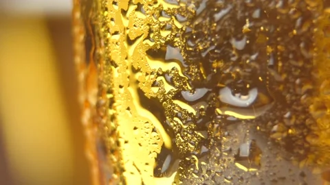 Cold light beer with bubbles in a glass and dripping condensate drops Stock Footage 88524185