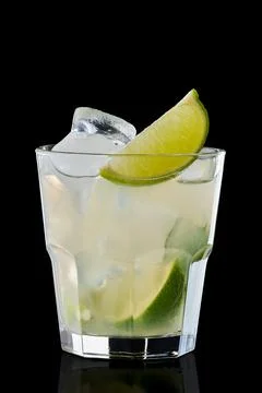 Cold lime refreshing drink in rocks glass isolated on black Foto stock