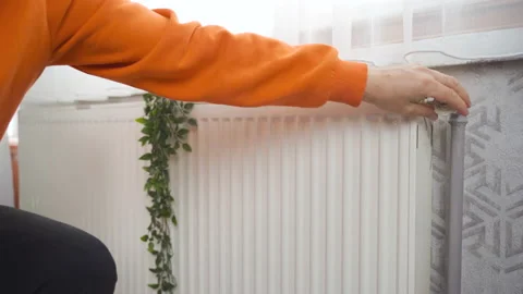 The cold man opens the valve of the combi boiler at home. Stock Footage 218650863