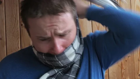 The cold man wraps himself in a warm scarf. coughs. disease, virus, infection Stock Footage 166631506