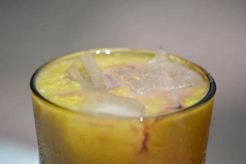 Cold mango beverage with ice on dark background Stock Photos