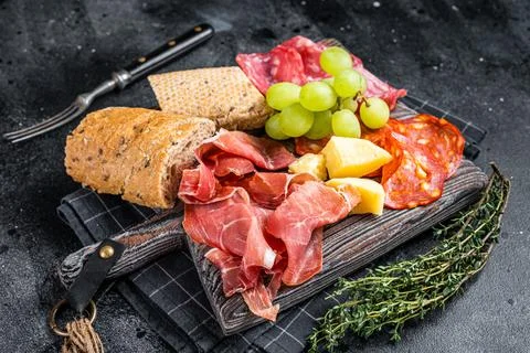 Cold meat plate, charcuterie - traditional Spanish tapas on a wooden board with Stock Photos