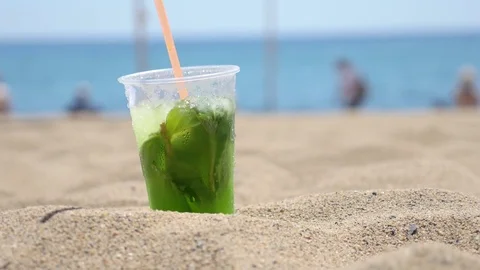Cold Mojito drink sitting on the sand Stock Footage 75689870