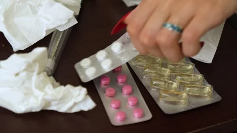 Cold pills on the nightstand. Hand picks up the pills Stock Footage 281343233