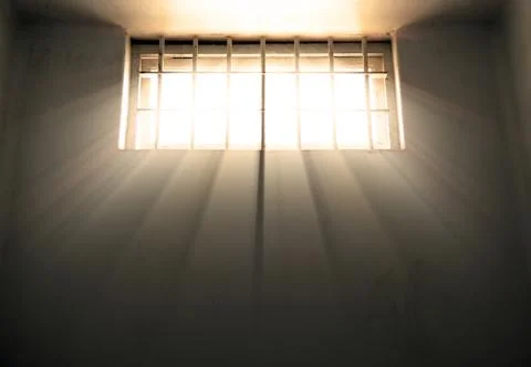 Cold prison cell with sunshine through window Foto stock
