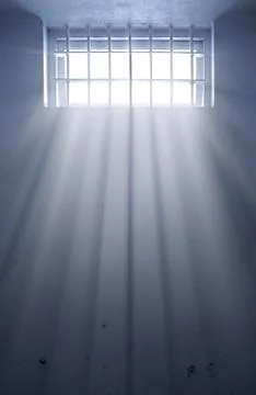 Cold prison cell with sunshine through window Stock Photos