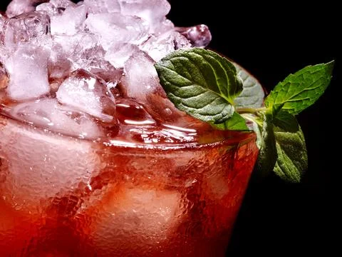 Cold red drink with raspberry and mint leaf on black background. Stock Photos