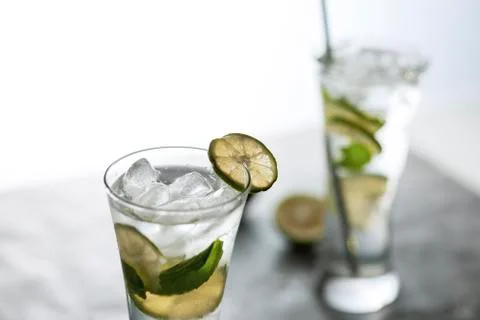 Cold refreshing beverage with sliced lime ripes and ice reverse light image i Photos