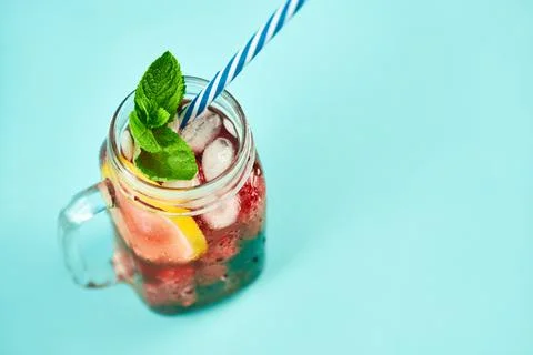 Cold refreshing cocktail with ice, mint and copy space on blue background Stock-Fotos