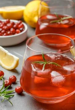 Cold refreshing drink of cranberry, lemon, rosemary and ice cubes Stock Photos