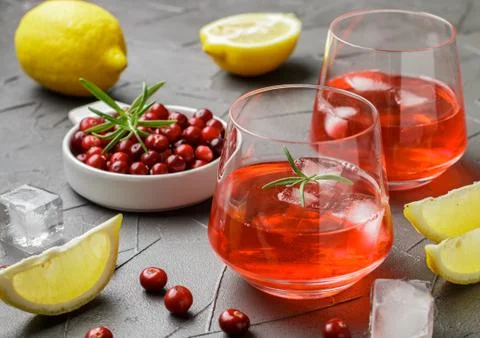 Cold refreshing drink of cranberry, lemon, rosemary and ice cubes Stock Photos