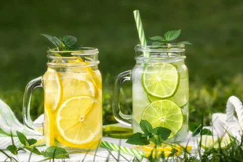 Cold refreshing homemade lemonade with mint, lemon and lime in mason jars on  Stock Photos