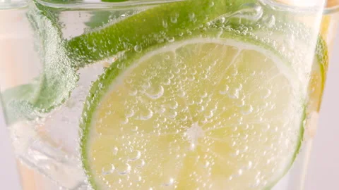 Cold refreshing lemonade or mojito alcoholic cocktail with ice cubes and fresh Stock Footage 154910480