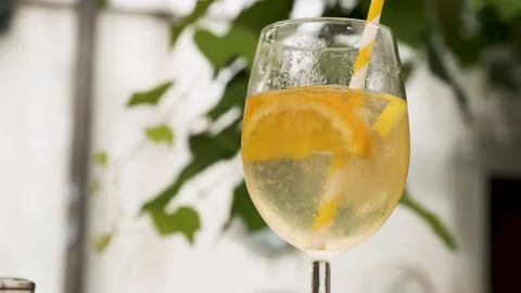Cold refreshing summer cocktail, soft drink cocktail with a straw, picking it up Stock-Footage 218591201