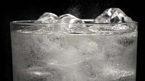 Cold refreshing tonic, lemonade or cocktail with ice cubes bubbling inside glass Stock Footage 219070706